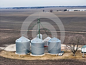 grain storage bins from the air with farm fields in the background