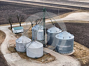 grain storage bins from the air with farm fields in the background