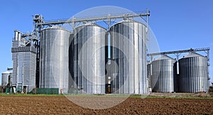 Grain storage bins with silos and distribution system
