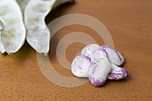 Grains of beetroot in the foreground, to the bottom pods of bean photo