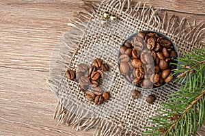 Grains of coffee and a branch of a christmas tree on a wooden table