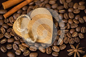 Grains of coffee close-up and decorative wooden heart. Concept of coffee love or a loved one. Image for any day and for