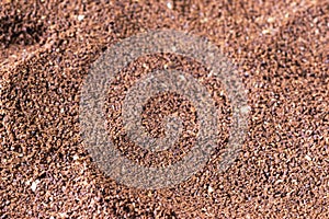 The grains of ground black coffee are very close. Close up ground coffee background. Brown coffee powder texture extreme closeup