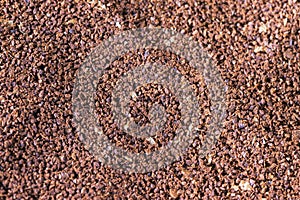 The grains of ground black coffee are very close. Close up ground coffee background. Brown coffee powder texture extreme closeup