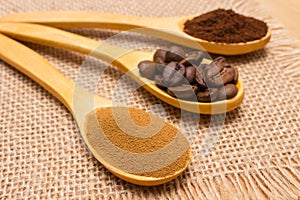 Grains, ground and instant coffee with wooden spoon on jute canvas