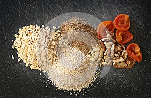 Grains, nuts, dry fruits on a black chopping board photo