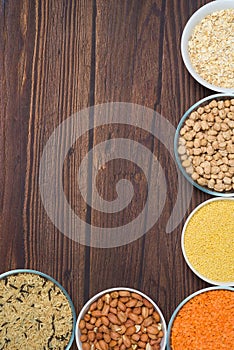 Grains red lentils, basmati rice, buckwheat, chickpeas, millet in plates. organic healthy cereals. on a wooden background. natural