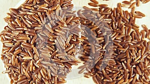 Grains in wooden spoons on wooden background top view