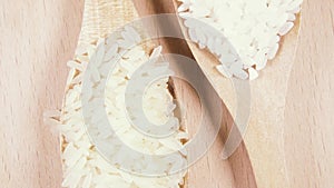 Grains in wooden spoons on wooden background top view