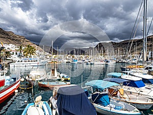 Gran Canaria, Spain - Feb 21, 2023: Colorful canarian fishing boats at the harbor in Puerto de Mogan, Gran Canaria,Spain
