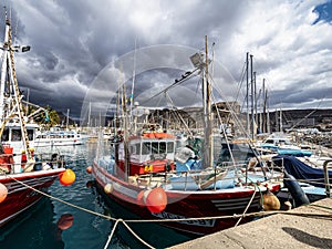 Gran Canaria, Spain - Feb 21, 2023: Colorful canarian fishing boats at the harbor in Puerto de Mogan, Gran Canaria,Spain