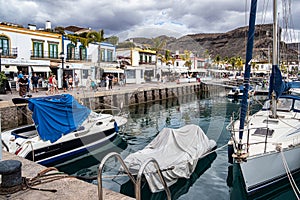 Gran Canaria, Spain - Feb 21, 2023: Colorful canarian fishing boats at the harbor in Puerto de Mogan, Gran Canaria,Spain