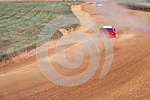 gran turismo races on the autocross track, skidding, dust and dirt from under the tires photo