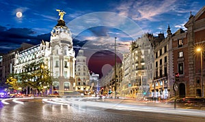 Gran Via street in Madrid with full moon rising photo