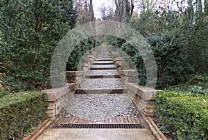 Beautiful stoned and brick stairs in middle of garden with small bushes