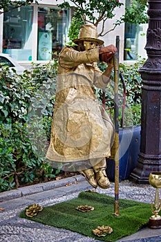 Granada, Spain - September 05, 2015: A street performer in disguise performing levitation trick