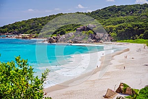 Grand Anse beach at La Digue island in Seychelles. Long white sand beach with blue lagoon, ocean waves and granite