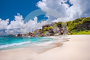 Grand Anse exotic beach at La Digue island in Seychelles. White sandy beach with blue ocean lagoon, white waves and