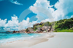 Grand Anse exotic pristine beach at La Digue island in Seychelles. White sandy beach with blue ocean lagoon, rolling