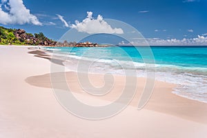 Grand Anse sandy exotic beach at La Digue island in Seychelles. Unrecognized tourists swimming and relax in blue lagoon