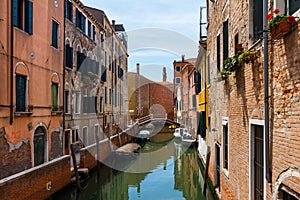 Grand Canal in Venice with boats and gandules docket motor boat near the bridge. Colorful residential house and small bridges