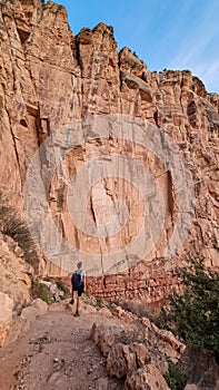 Grand Canyon - Man hiking along Bright Angel trail with panoramic aerial overlook of South Rim of Grand Canyon, Arizona, USA