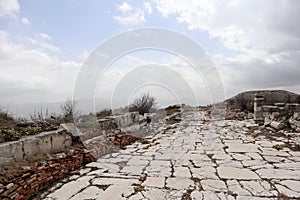 Grand colonnaded street with white marble pavement in ruins of the ancient city Sagalassos lost in Turkey mountains