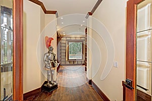 Grand foyer with butter yellow walls, brown wooden trim