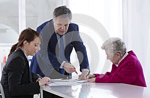 Grand mother signing insurance contract and donation to her gran