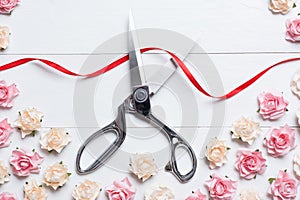 Grand opening concept with scissors cutting red ribbon on white