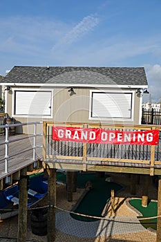 Grand Opening sign in front of a shack on a boardwalk