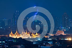 Grand palace bangkok with bangkok city skyscrapers at night in B