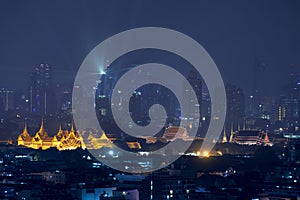 Grand palace with Bangkok city skyscrapers at night in Bangkok