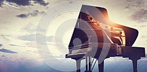 Grand piano on sunset sky background