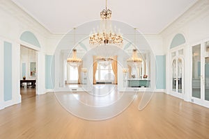 grand room with white arcades and chandeliers