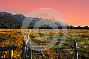 Grand Teton range under a pink sky at sunrise