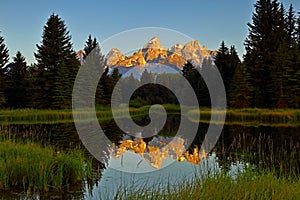 The Grand Teton sunrise reflection at Schwabacher`s Landing in Grand Teton National Park