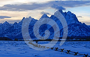 Grand Tetons split rail fence view at alpenglow twilight sunset under lenticular clouds in Grand Tetons National Park in Wyoming