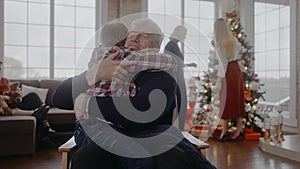 Grandad hugging his grandson sitting on a chair at Christmas Eve