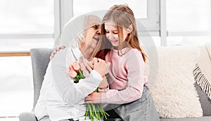 Grandaughter gives flowers to grandmother