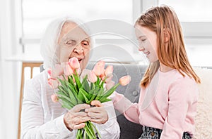 Grandaughter gives flowers to grandmother