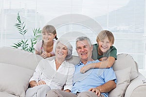 Grandchildren and grandparents sitting on couch