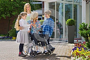 Grandchildren visiting grandmother in wheelchair