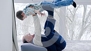 Granddad fool around with grandchildren lying on floor at home