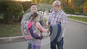 Granddaughter first grader runs to meet grandma and grandpa who meet her after school.
