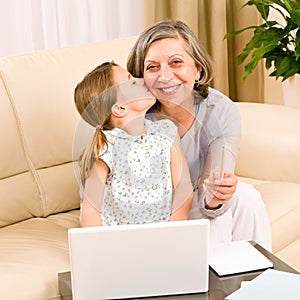 Granddaughter giving kiss to grandmother smiling