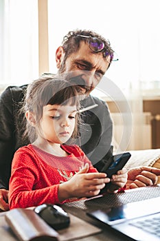 Granddaughter and grandfather using smartphone