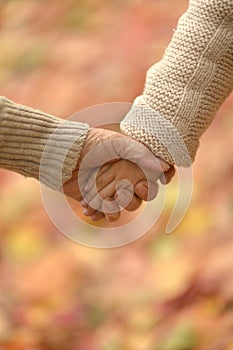 Granddaughter and grandmother holding hands close up