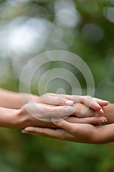 Granddaughter and grandmother holding hands close up