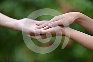 Granddaughter and grandmother holding hands close up